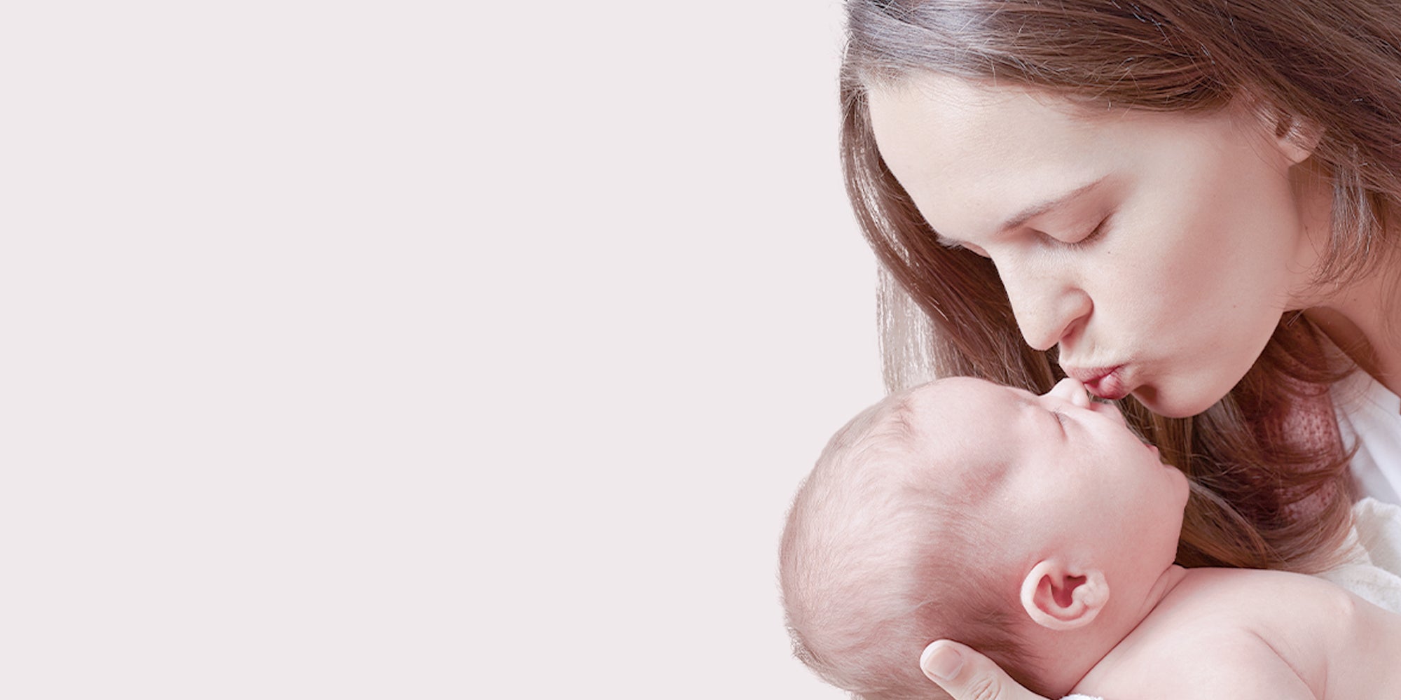 Mother holding newborn dressed in soft Supima cotton baby clothes by KottonSpa